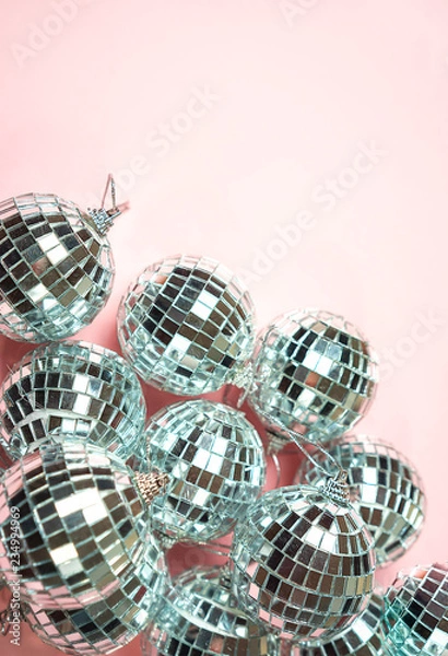Fototapeta Silver disco balls for decoration party on pastel pink gradient background. Winter New Years Eve party holiday concept. top view, flat lay close up mirror ball. Frame with room for copy.