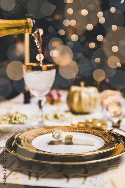 Obraz New year table setting with exclusive and luxury golden cutlery, over a tabletop with celebrations world " new year" against a background with great light and bokeh.