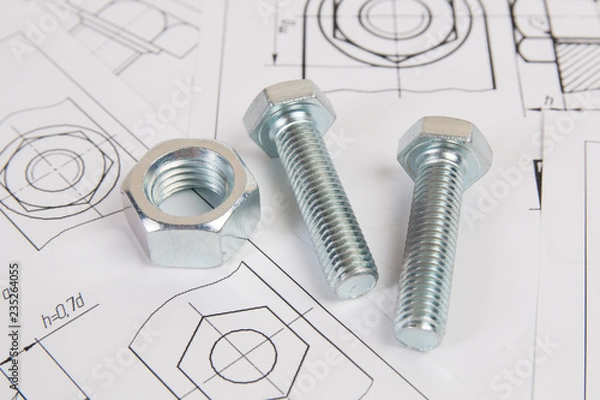 Fototapeta Technical drawings of bolt and nut. Engineering, technology and metalworking. Metal bolt and nut on printed drawings background.