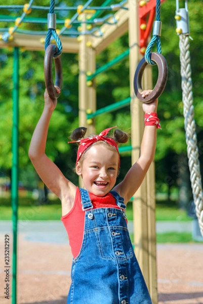 Fototapeta little girl is playing on the playground