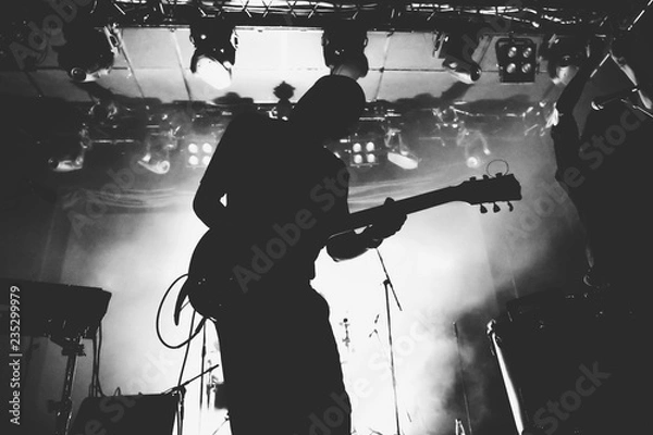 Obraz Guitarist silhouette on a stage in a bright stage lights. Black and white
