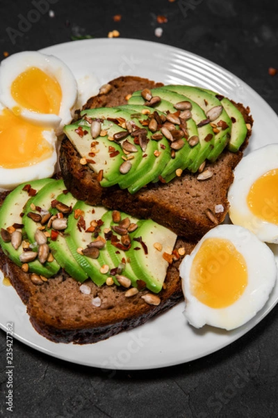 Obraz Tasty and healthy Breakfast of sandwiches with avocado and egg on a white plate. The concept of proper nutrition