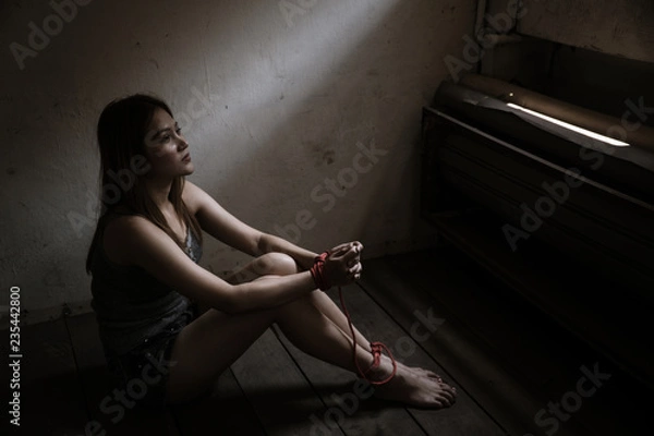 Fototapeta Victims of abducted women get wrists and feet in red. You have no way to fight or resist. She needs help. Hostage concept or female kidnapped from robber. Copy space. Dark Concepcion.
