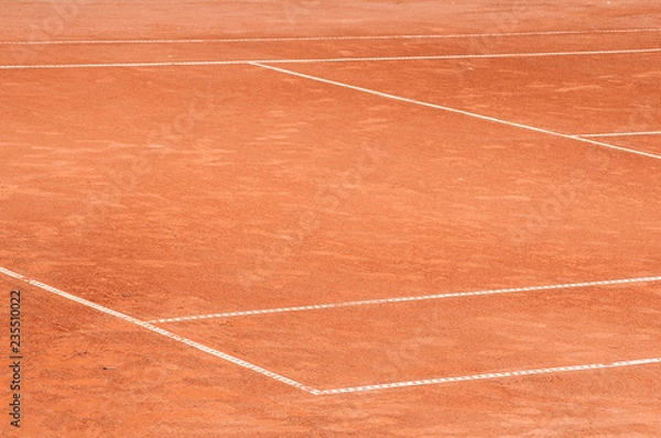 Fototapeta Part of empty used red clay tennis court playground surface with white lines closeup
