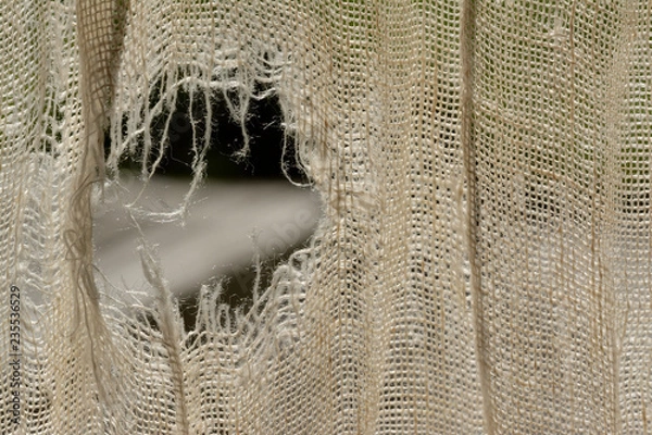 Obraz Woven linen, ripped, backlighted. Tear to the left. Tissues, curtain. Natural.