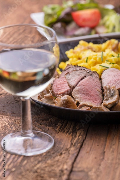 Obraz Weißwein und schwäbisches Schweinefilet mit Spätzle auf Holz