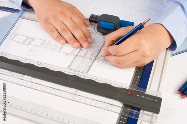 Obraz Architect working on architectural plans in the office