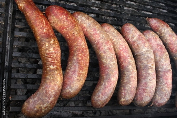 Fototapeta Raw stuffed sausages on a grill