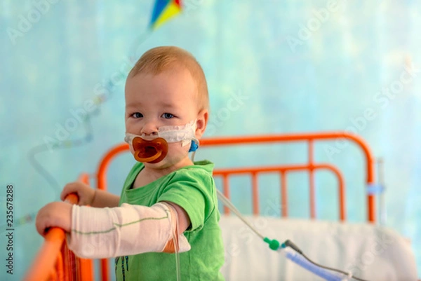 Obraz little boy in hospital bed with iv infusions and oxigen