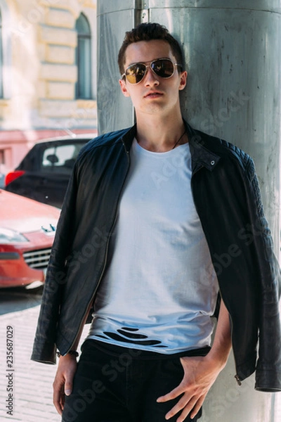 Obraz Attractive, sexy guy standing on the street in sunglasses. self-confidence, flatulence and arrogance. model, posing, portrait of a young man