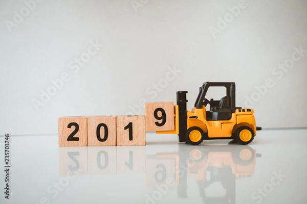 Fototapeta Miniature forklift lift up year 2019 wooden block using as business and industry concept