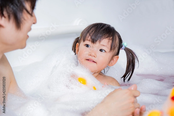 Fototapeta お父さんと一緒にお風呂に入る幼い女の子。親子、父子、娘。育児、衛生、清潔イメージ