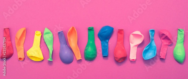 Fototapeta Banner Set of colored balloons on pink background Flat lay top view