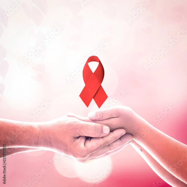 Obraz World AIDS day concept: Two human hands holding red ribbon.