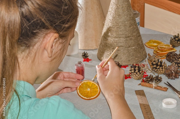 Obraz Девочка  мастерит поделку к празднику Рождества в виде необычной елки в стиле арт-деко.