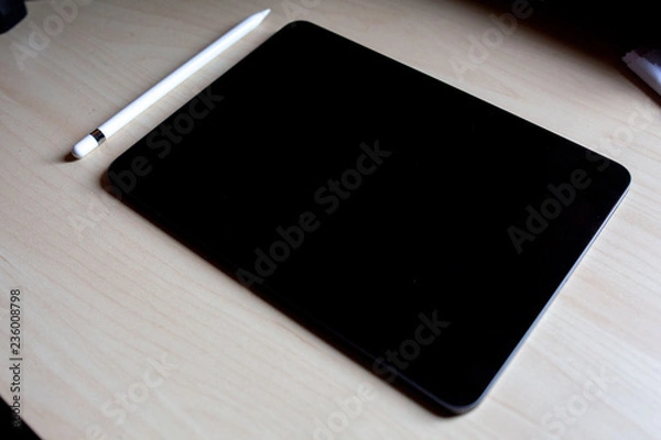 Fototapeta new pro tablet on the table with pencil blank screen