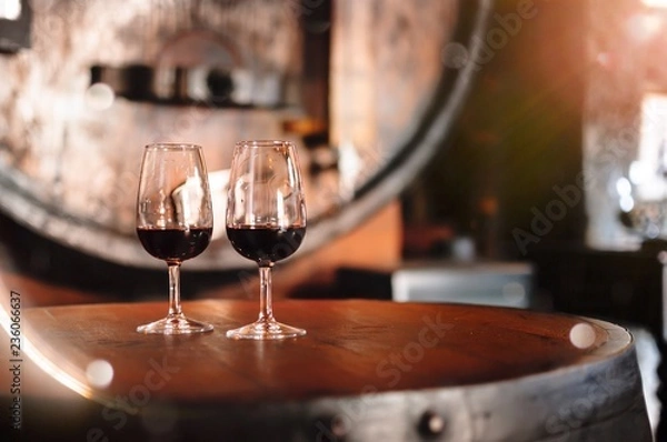 Obraz Two glasses of Porto Wine standing on the barrel in wineyard's restaurant