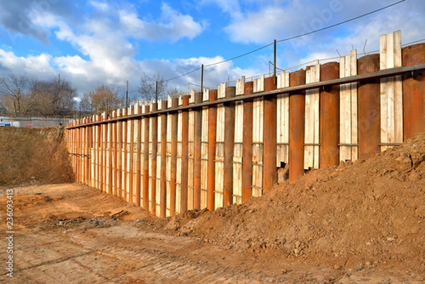 Fototapeta Construction site; construction pit with metal pipes supporting the ground.