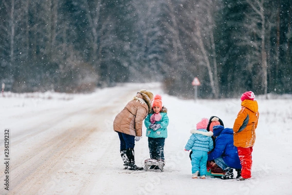 Obraz big family with sled in snowy woods. Mothers with children on winter walk