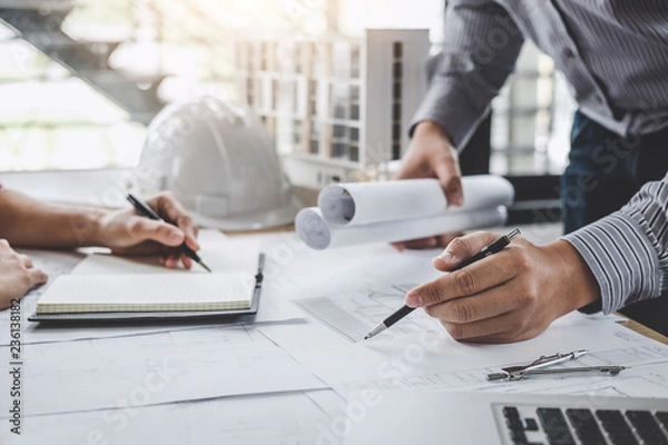 Obraz Construction and structure concept of Engineer or architect meeting for project working with partner and engineering tools on model building and blueprint in working site