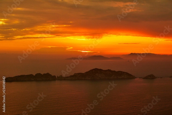 Fototapeta Sunset over the sea. Bright colorful background with sun, sea and rocks
