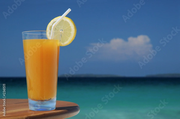 Obraz glass of mango juice with straw and lemon twist.
