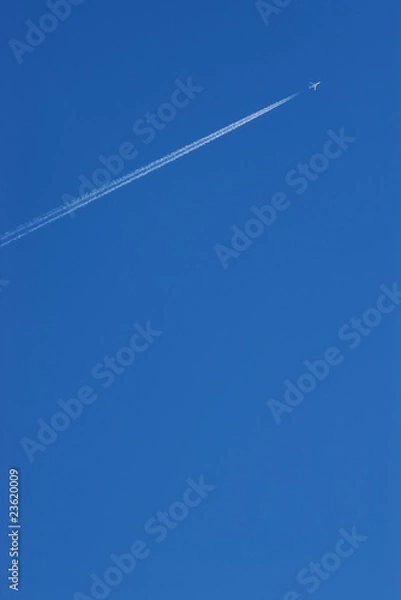 Obraz Airplane contrail against blue sky with copy space
