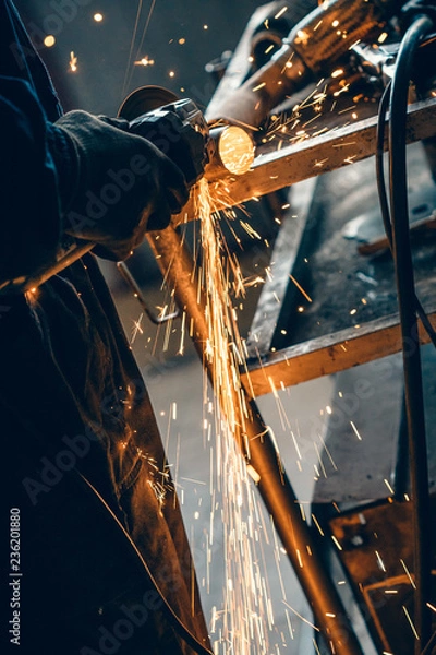 Fototapeta Close up of car mechanic hands welding grinding machine.Sparks of grinding machine while cutting car exhaust pipe