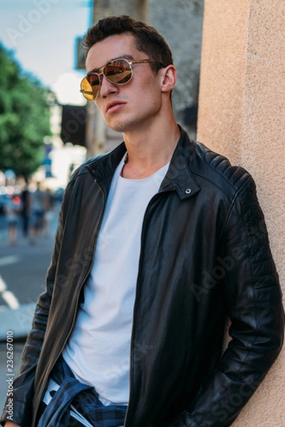 Obraz Attractive, sexy guy standing on the street in sunglasses. self-confidence, flatulence and arrogance. model, posing, portrait of a young man