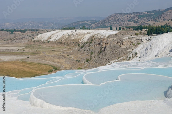Fototapeta cotton castle in Pamukkale, Turkey. White limestone cliffs with water, against the sky