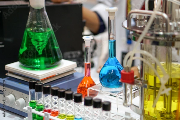 Fototapeta Magnetic laboratory agitators. The green liquid is mixed in a conical glass flask.