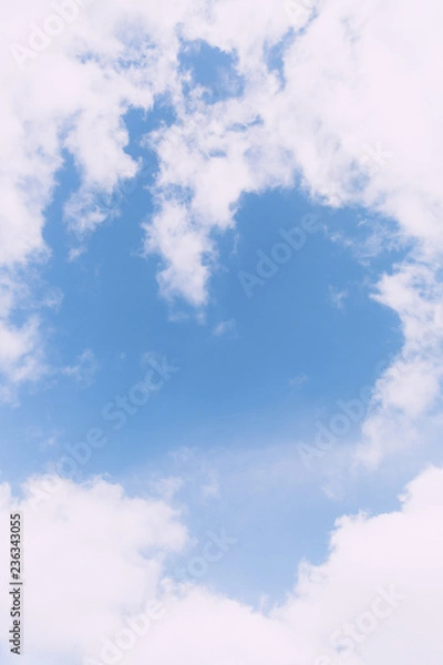Fototapeta Fluffy clouds making a heart shape up in the blue sky 