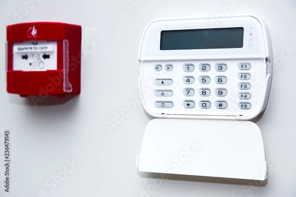 Fototapeta alarm control panel and fire button on a light gray wall, close-up of the security password entry system to activate and set the alarm.