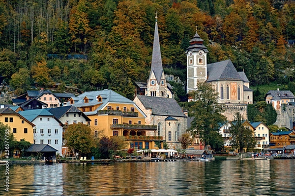 Obraz Beautiful scenic view of Austrian alps. Famous church in Hallstatt mountain village. Sunny day lake view on Hallstatt alps mountains. Location: resort village Hallstatt, Salzkammergut, Austria, Alps