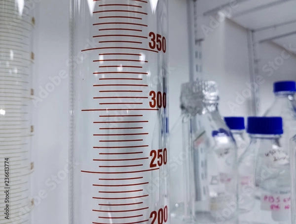 Fototapeta Graduated cylinder for measuring and transporting liquids and chemical substances in a laboratory. Concept of measurement in medical tests and scientific research.