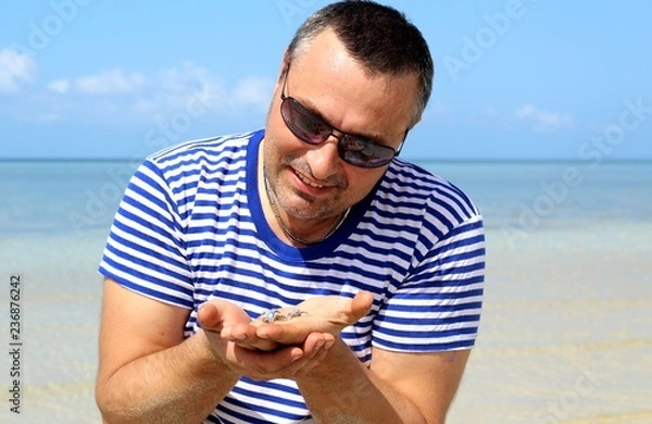 Fototapeta A man holds in the palms of blue Filipino crabs