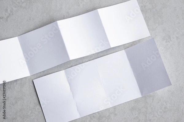 Fototapeta Blank portrait mock-up paper. brochure magazine isolated on gray, changeable background / white paper isolated on gray cement backdrop.