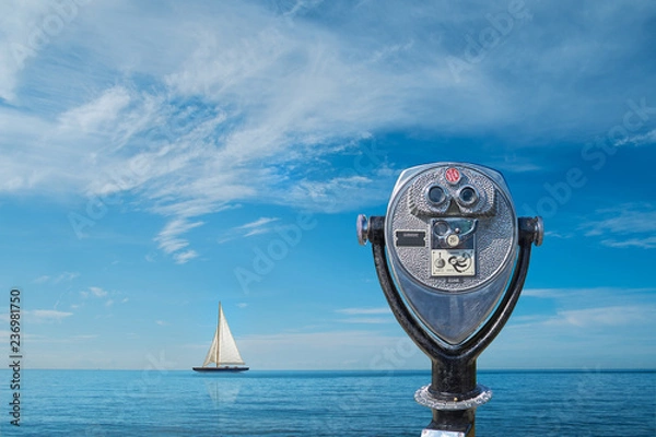 Obraz Binocular viewer overlooking sea with yacht on horizon