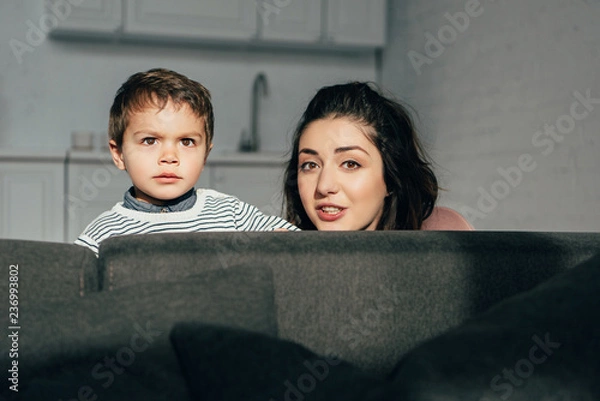 Fototapeta portrait of mother and little son sitting on sofa at home