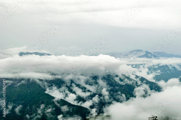 Fototapeta clouds floating over the mountain range, seen from the Zero Point, after a long trek through the forest in Binsar Wildlife Sanctuary, rainy season