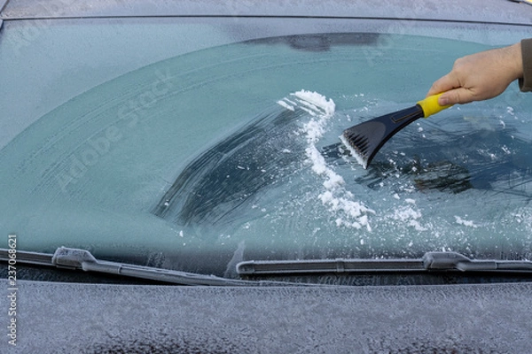 Fototapeta Hand scratching ice from car window