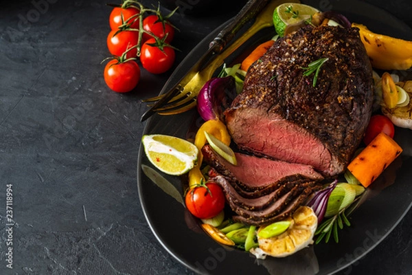 Fototapeta Club Beef steak with pepper sauce and Grilled vegetables on dark wooden background. Roas beef. Copy space.