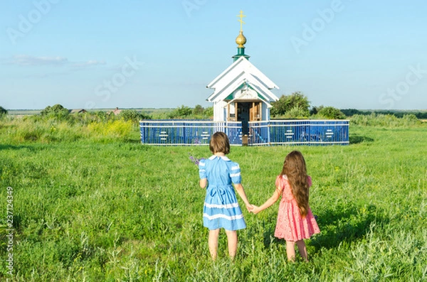Obraz Девочки идут в деревенскую часовню взявшись за руки.