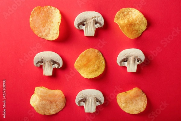 Fototapeta Tasty crispy potato chips with cut mushrooms on color background, top view