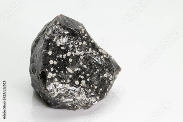 Fototapeta Obsidian: a naturally occurring volcanic glass formed as an extrusive igneous rock, from Vesuvius volcano, isolated on a white background, Naples, Italy