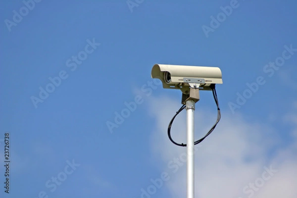 Obraz Security camera in cloudy blue sky background.