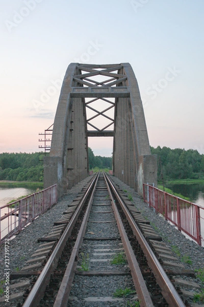 Fototapeta stone railway bridge over the river going into the distance