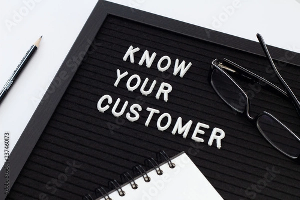 Fototapeta Know Your Customer - business concept, white text message on black board with notebook