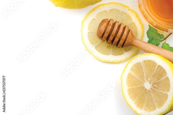 Fototapeta Honey dipper stick and Yellow Lemon citrus half slices with leaf on white background