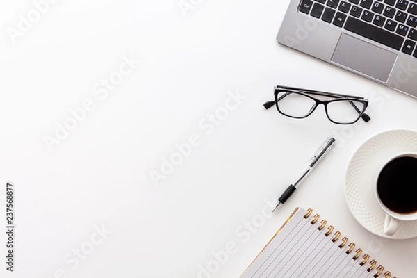 Fototapeta Office desk table with laptop, cup of coffee, notebook, glasses and supplies, isolated on white background. Top view with copy space, flat lay...
